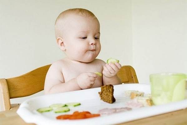 Bé thích dùng tay để bóc và cho thức ăn vào miệng là một trong những dấu hiệu cho thấy bé đã sẵn sàng ăn dặm